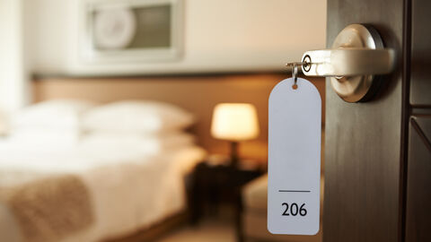 Blick in ein Hotelzimmer mit Schlüssel im Schloss
