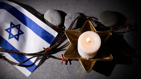 Eine Kerze und eine Israelflagge erinnern an die Reichspogromnacht
