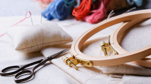 Stickset mit Rahmen, Nadeln, Fäden und einer Schere