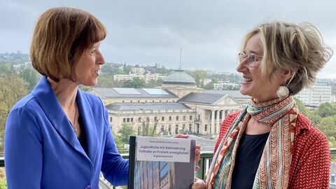 Zwei Personen halten eine Studie in den Händen.