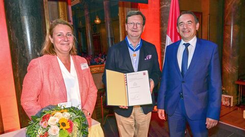 Kultusminister Lorz und Gerald Kink nebeneinander mit der Urkunde.